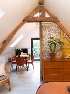 an attic room with a table and chairs at Les Bobos à la ferme in La Madelaine-sous-Montreuil