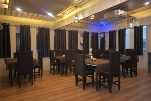 a restaurant with tables and chairs in a room at Heavens Hotel in Agra