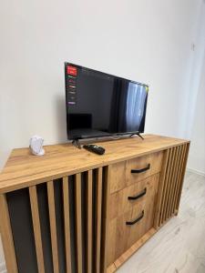 a tv on top of a wooden stand with a television at Garsonieră in Chiajna