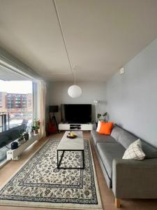 a living room with a couch and a table at Cozy private room centrally in Jessheim in Jessheim