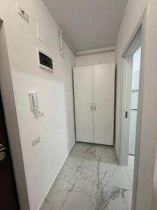 a hallway with white walls and a white cabinet at Garsonieră in Chiajna