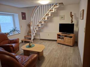 a living room with a staircase and a television at NEU! Ferienwohnung Hanka in Crostwitz