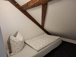 a room with a white wall with a pillow and a beam at NEU! Ferienwohnung Hanka in Crostwitz