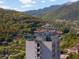 a building in a town with mountains in the background at Verinn Apart Hotel in Dilijan