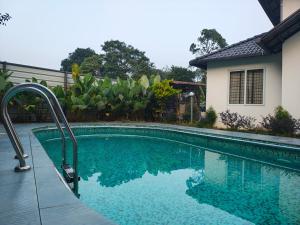 a swimming pool in front of a house at Tender leaf inn in Koroth