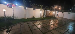 a backyard at night with a white fence at Tender leaf inn in Koroth