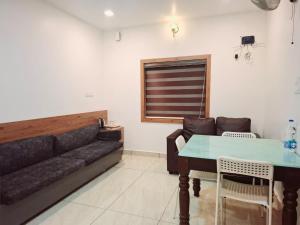 a living room with a couch and a table at Tender leaf inn in Koroth