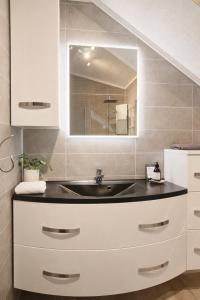 a bathroom with a sink and a mirror at Modern seafront cabin with sauna 8 mins to Leknes in Storeidet