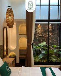 a bedroom with a bed and a window with a fishtank at Sampai Villa Prambanan in Randugunting