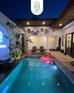 a swimming pool with a pink swan in the middle at Sampai Villa Prambanan in Randugunting