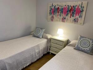 a bedroom with two beds and a lamp on a night stand at Casa Costa Atlantica in Costa Ballena +28 photos