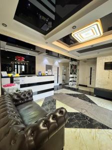 a living room with a leather couch and a kitchen at Garnet hotel in Bishkek