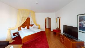 a bedroom with a bed and a flat screen tv at Hotel Seeperle in Langenargen