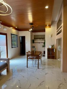 a dining room with a wooden table and chairs at Violegre Homestay - KABLON in General Luna