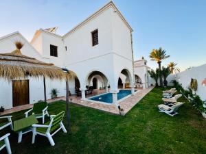 an external view of a villa with a swimming pool at Dar Sofien Erriadh Djerba in Erriadh
