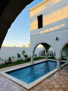 a villa with a swimming pool and a building at Dar Sofien Erriadh Djerba in Erriadh