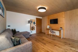 a living room with a couch and a desk at Hotel Tirolerhof in Terento