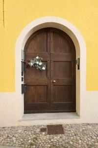 a large wooden door with a flower arrangement on it at Apartment Meringa in Pettenasco