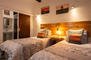 a bedroom with two beds and a sink at The Trout Fly Guest House in Port Ellen