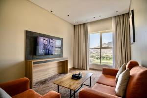 a living room with a couch and a tv at W Suites Hotel Sama Abha in Abha