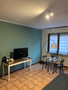 a living room with a desk and a table and chairs at Appartamento ONE in Novara