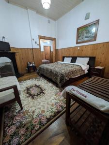 a bedroom with two beds and a fireplace and a rug at The Trevene Hotel in Nuwara Eliya +85 photos