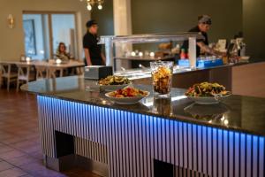 eine Bar mit Schüsseln voller Essen auf einer Theke in einem Restaurant in der Unterkunft Valjeviken in Sölvesborg + 12 Fotos