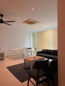 a living room with a couch and tables and chairs at Poshpack Skyline Hostel in Kuala Lumpur +26 photos