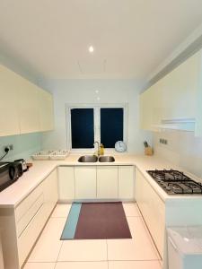 a white kitchen with a sink and a stove at Poshpack Skyline Hostel in Kuala Lumpur