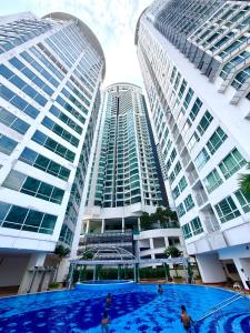 two tall buildings with a swimming pool in between them at Poshpack Skyline Hostel in Kuala Lumpur
