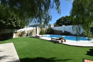 a yard with a pool with two chairs and a table at Resort Villa Las Palmeras in Roquetas de Mar