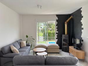 a living room with a couch and a tv at Jacarandas Islantilla in Islantilla