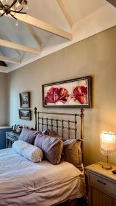 a bedroom with a bed and a painting on the wall at Winner in the Overberg in Bredasdorp