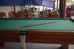 a green pool table with a cue stick on it at Mutary II in Santa Cruz Cabrália