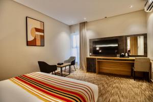 a hotel room with a bed and a desk at W Suites Hotel Sama Abha in Abha +15 photos