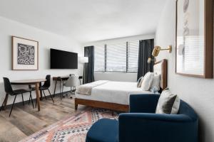 a hotel room with a bed and a table and chairs at Lodgeur Upper Kirby, Houston - Close to Greenway Plaza, Galleria, Montrose in Houston