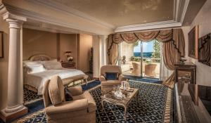 a bedroom with a bed and a living room at Rome Cavalieri, A Waldorf Astoria Hotel in Rome +83 photos