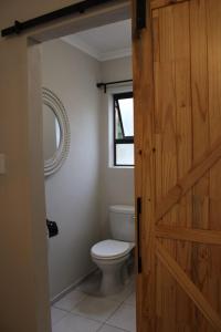 a bathroom with a toilet and a wooden door at The White Castle in Chartwell +25 photos