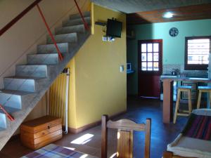 a living room with a staircase and a kitchen at Yataí Casas in Colón