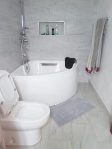 a white bathroom with a toilet and a sink at Nhambavale Niara House in Chidenguele +11 photos