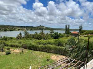 a view of a river with a house in the distance at Nhambavale Niara House in Chidenguele