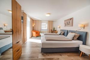 a bedroom with two beds and a living room at Apart-Pension Oberreiter in Fusch an der Glocknerstraße