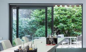 a dining room with a long table and a large window at Ferrotel Duisburg - Partner of SORAT Hotels in Duisburg