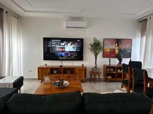 a living room with a couch and a flat screen tv at Villa EWA in Kika