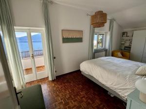 a bedroom with a bed and two large windows at Raggio di Sole Villa in Oggebbio +40 photos