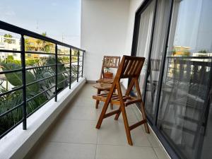 two wooden chairs sitting on a balcony at Villa EWA in Kika