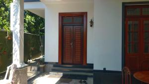 a house with a wooden door and a staircase at Negombo New Villa in Negombo