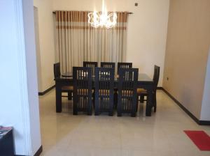 a dining room table with chairs and a chandelier at Negombo New Villa in Negombo +19 photos