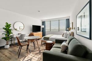 a bedroom with a couch and a bed and a table at Lodgeur Upper Kirby, Houston - Close to Greenway Plaza, Galleria, Montrose in Houston