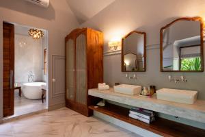 a bathroom with two sinks and a bath tub at Upendo Beach Boutique Hotel Zanzibar in Michamvi +40 photos